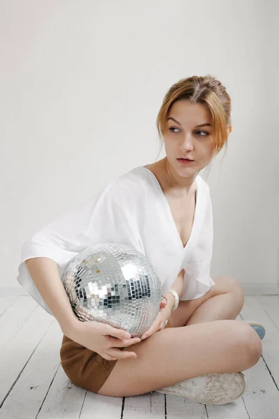 Mujer joven sosteniendo bola disco — Foto de Stock