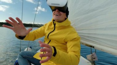 Casual adam Vr gözlük ve smartphone ve yelkenli tekne üzerinde oturan ve mutlu görünüyordu yaşıyor.