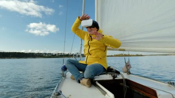 Man met Virtual Reality bril, genieten van zittend op een zeilboot en op zoek gelukkig. — Stockvideo