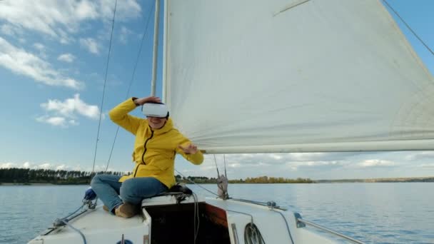 Człowiek z okulary wirtualnej rzeczywistości, ciesząc się siedząc na łodzi żaglowej i wyglądający zadowolony. — Wideo stockowe
