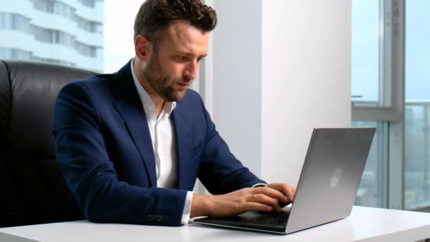 Empresario escribiendo en el portátil en la oficina — Vídeo de stock