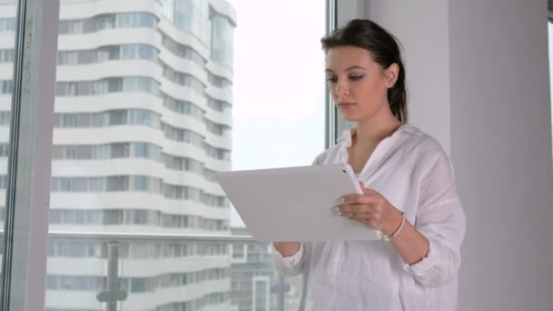 Jonge zakenvrouw die Tablet op kantoor gebruikt — Stockvideo