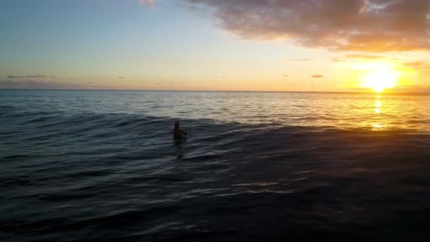 Luftaufnahme: Mädchen entspannt am Surfbrett sitzend in Zeitlupe — Stockvideo