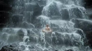 Arka plan şelale Yoga poz oturan adam