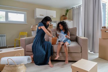 Kızı olan anne taşınmak için eşyalarını topluyor. Karışık ırk ailesi, Afrikalı Amerikalı kız ve Asyalı anne..