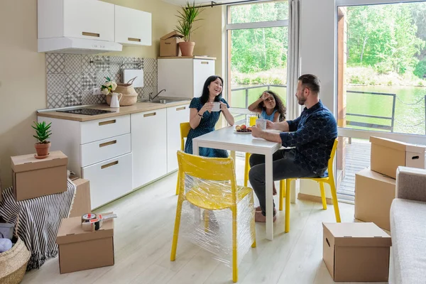 Glücklich gemischte Rasse Familie Familiengruppe ziehen in Mietimmobilien. Positiver Blick auf das Um- oder Auspacken der Kartonverpackung durch den verspielten Papa — Stockfoto