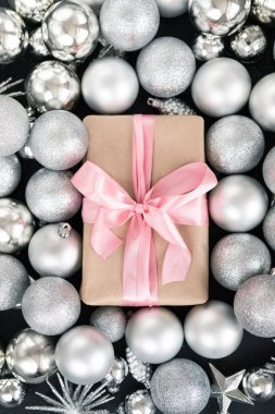Noel arkaplanı süslemeli, hediye kutusu pembe kurdeleli, siyah masa üzerinde fotokopi alanı olan. Noel süsleri ve hediye. Kış tatili kavramı