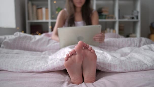 Technologie, internet en mensen concept - gelukkige jonge vrouw liggend in bed met tablet pc-computer thuis slaapkamer — Stockvideo