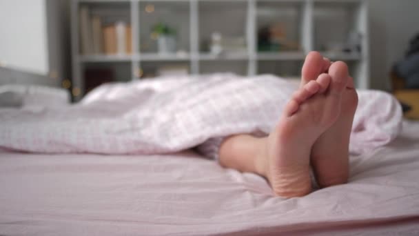 Vista de cerca de los pies acostados en la almohada blanca suave en la cama — Vídeo de stock