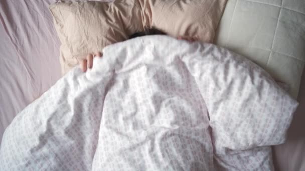 Bovenaanzicht van een jonge aantrekkelijke vrouw stretching handen terwijl liggend in bed in de ochtend — Stockvideo