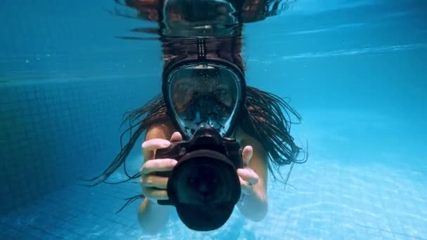 Menina viajante na Ásia. Jovem feliz com belo cabelo longo nadar debaixo de água com câmera na piscina de fontes termais. Indonésia, Bali . — Vídeo de Stock