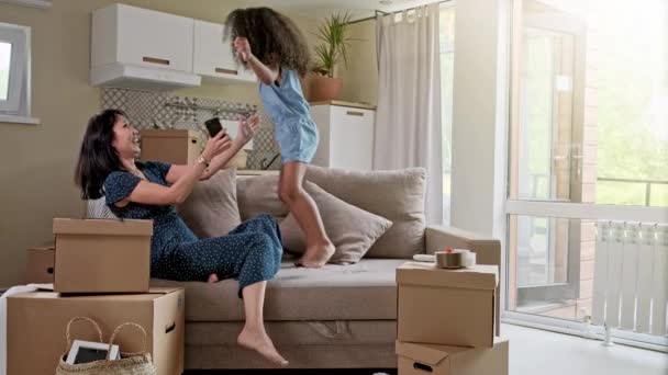 Young mother and her little daughter jumping on bed. Funny pillow fight. Play together and enjoy the moment Family time on weekend. — Stock Video