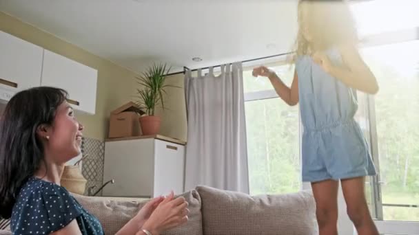 Junge Mutter und ihre kleine Tochter springen auf dem Bett. Lustige Kissenschlacht. Gemeinsam spielen und den Moment genießen, in dem die Familie am Wochenende Zeit hat. — Stockvideo