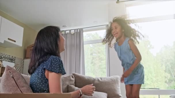 Młoda matka i jej córeczka wskakują do łóżka. Zabawna walka na poduszki. Graj razem i ciesz się chwilą Rodzinny czas w weekend. — Wideo stockowe