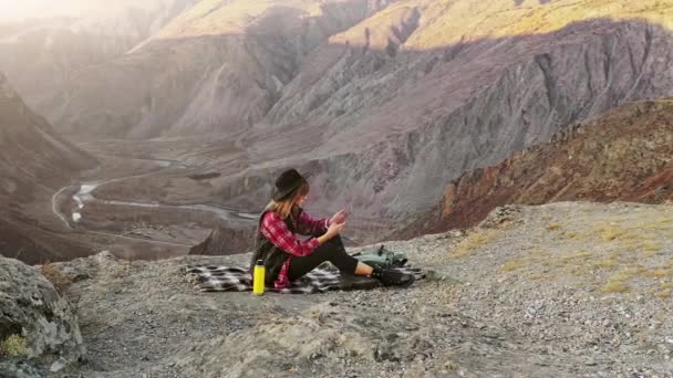 Mujer excursionista uso tableta digital en el acantilado pico de montaña — Vídeo de stock