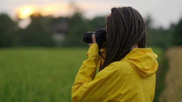 Joven fotógrafo hermoso con la cámara profesional. Disparando, riendo y divirtiéndose. Sonríe — Vídeos de Stock