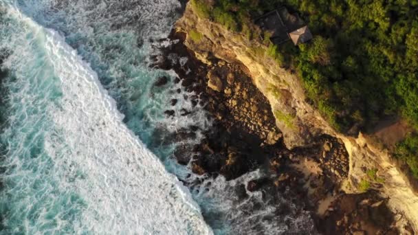 Les grosses vagues roulent d'en haut. Vue de haut en bas sur drone 4k sur l'océan bleu turquoise, vagues de rupture, blanchisserie. Journée ensoleillée sur la mer. Une énorme houle qui frappe le rivage. Ondes puissantes Bali, Indonésie — Video