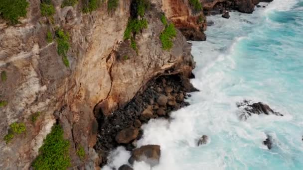 Les grosses vagues roulent d'en haut. Vue de haut en bas sur drone 4k sur l'océan bleu turquoise, vagues de rupture, blanchisserie. Journée ensoleillée sur la mer. Une énorme houle qui frappe le rivage. Ondes puissantes Bali, Indonésie — Video