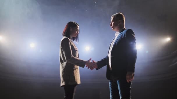 Politici schudden elkaar de hand na debat. De actie vindt plaats op het podium, schijnwerpers op de achtergrond — Stockvideo