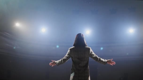 Experto realizar en el discurso del escenario a la audiencia moderna sentada y escuchando en un gran salón. Empresaria comunicándose con un oyente en la convención del taller para jóvenes empresarios — Vídeo de stock