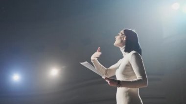 Uzman gerçekleştirmek üzerinde oturan ve büyük salonunda dinleme modern kalabalık seyirci sahne adresine. Kadın girişimci genç businesspersons için bir dinleyici atölye Kongre iletişim