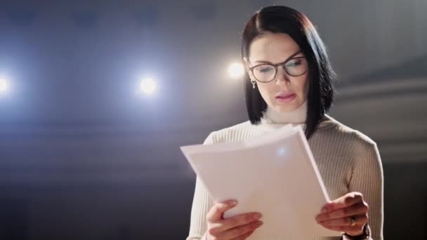 L'allenatore finanziario femminile gesti emotivi colloqui dal palco con gli spettatori al forum. Troppe persone anonime lavoratori e studenti siedono in un grande auditorium e guardano lo sfondo del workshop — Video Stock