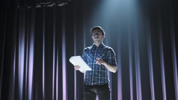 Postav se komediantovi na pódium. Mladý muž mluví vtip do mikrofonu nebo zpívá písně. — Stock video