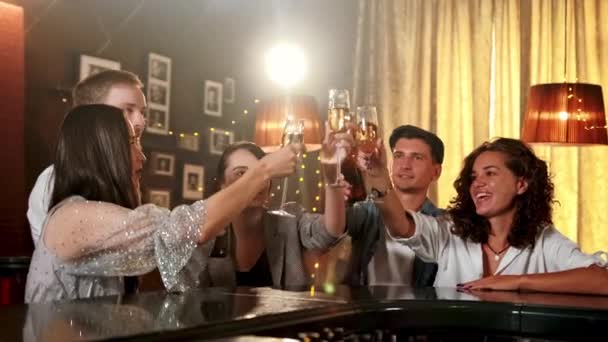 Ungdomar firar något på kaféet. De är klinkande glas med öl och cocktails, drickande och pratande. Modernt firande i barkonceptet. — Stockvideo