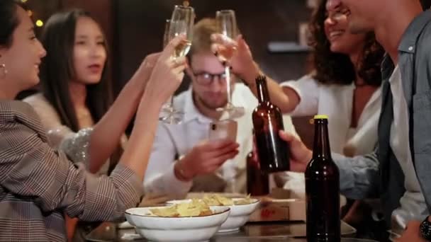 Amigos en un pub celebran y se divierten, un tipo está mirando un teléfono inteligente, y no hablar con otras personas. El problema de la sociedad moderna . — Vídeo de stock