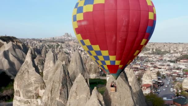 Kleurrijke rood-blauwe gele kleuren heteluchtballonnen luchtDrone vlucht. De grote toeristische attractie van Cappadocië. Cappadocialandschap met rotsen en huizen. Goreme, Cappadocië, Turkije — Stockvideo