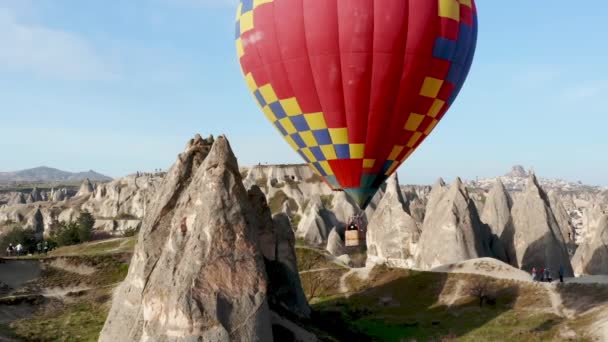 Colourful Red Blue Yellow Colours Hot Air Baloons Aerial Drone Flight. The great tourist attraction of Cappadocia. Cappadocia landscape with rocks and houses. Goreme, Cappadocia, Turkey — Stock Video