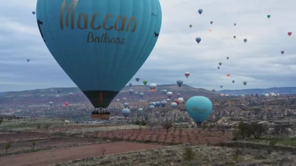 गोरम, तुर्की 17 अक्टूबर 2009: कैपाडोसिया, तुर्की में गोरेम के पास चट्टान संरचनाओं पर उड़ान भरने वाले वाणिज्यिक गर्म हवा के गुब्बारे — स्टॉक वीडियो