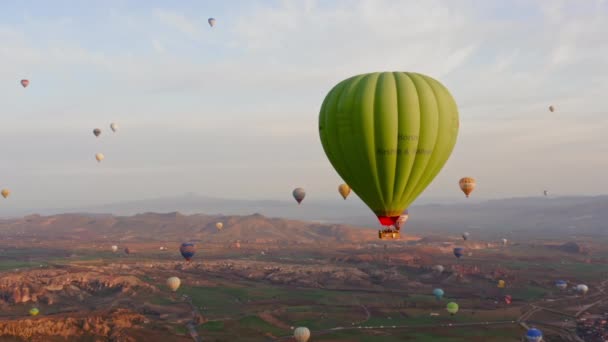 GOREME , TURKEY - OCTOBER 17, 2009: Commercial hot air balloon flying over rock formations near Goreme in Cappadocia, Turkey — Stock Video
