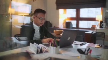 Bir adamın portresi geceleri gözlüklerle dizüstü bilgisayarda çalışıyor. İş adamı geç saatlere kadar çalışır, monitöre bakar, gözlüklerdeki yansımalar, ofiste dizüstü bilgisayar kullanan erkek borsa simsarı.