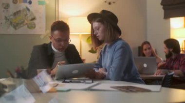 Enerji dolu bir şekilde projeyi tartışırken, iki farklı insan masada oturuyorlar. Akşam Vakti. Dijital Tablet Üzerine Kalemle Çizim.