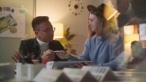 Deux personnes élégantes et diverses sont assises à la table tout en discutant énergiquement du projet. L'heure du soir. Dessin avec stylo sur tablette numérique .