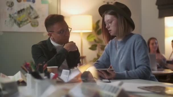 Genç Şık Tasarımcılar, Bir Tablet Üzerinde Dizüstü Bilgisayarlı Kalem, Arkaplan Kadın ve Erkek Çizerek Bir Proje Tartışıyor. — Stok video