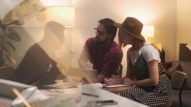 Tasarımcı, dizüstü bilgisayarı ve tableti olan bir müşteriyle konuşuyor. Neşeli Genç Adam Ev Planını Onayladı. Memnun Müşteriler Mimarlarla İletişim Kurar, Erkek İç Tasarım Çizer