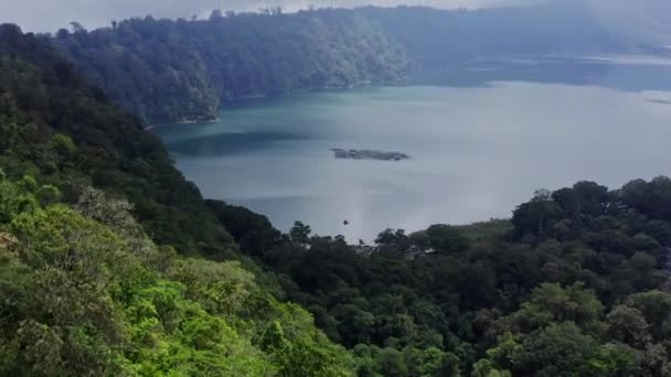 Luftbild Grüne Berge und tropische Bäume am Ufer des Sees. Bali, Indonesien. — Stockvideo