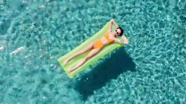 Aerial - L'uomo adulto si tuffa nella piscina mentre la ragazza nuota su un materasso sveglia e ride . — Video Stock