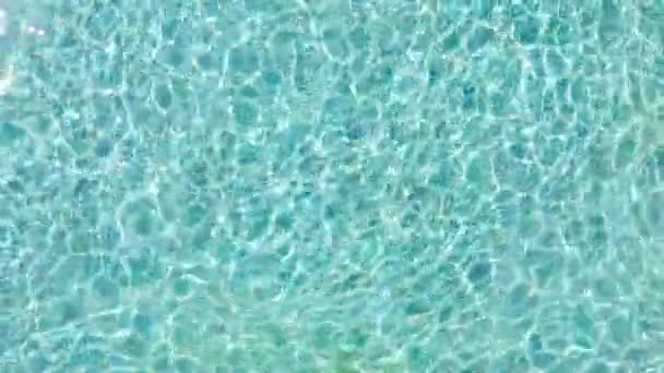 Bazén s modrou vodou. Povrchová textura vody. Top View. Letecký pohled na pozadí čistého bazénu vlnky a vlna, odraz slunečního svitu Top View. — Stock video