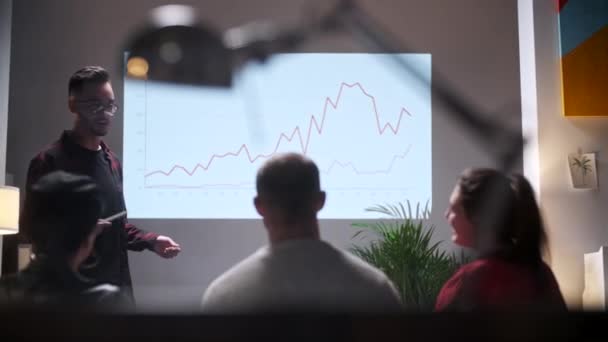 Reunião de negócios. Equipe de escritório analisa o crescimento do negócio. Young Man Interessado em público. No monitor gráfico de crescimento da tela — Vídeo de Stock