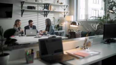 Meslektaşlar ve müşteriler dizüstü bilgisayar ve tabletle strateji konuşuyorlar. Yaratıcı Ofis Üretici İş Arkadaşları Şirket Toplantısı Masasında Bekliyor. Takım Çalışması ve Sosyal Konseptler
