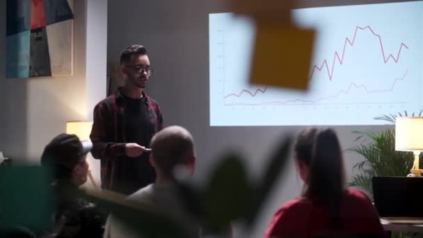 Zakelijke bijeenkomst. Office Team analyseert de groei van het bedrijfsleven. Jongeman geïnteresseerd in publiek. Op het scherm Groei Grafiek Monitor — Stockvideo