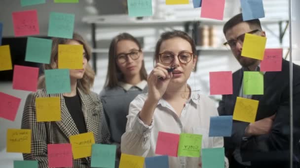 Creative Business Team Ideias Brainstorming trabalhando juntos perto de parede de vidro com notas pegajosas. Os colegas aprovam. Conceito de sucesso empresarial — Vídeo de Stock