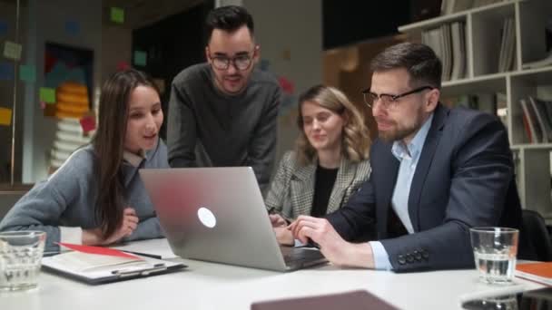 In Creatief Kantoor Productieve Medewerkers Staande aan de Tafel, Bedrijfsbijeenkomst. Collega 's en klanten praten strategie met laptop en tablet. — Stockvideo