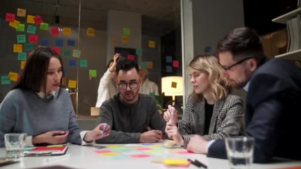 Business Team Brainstorming Použití barevných štítků na stole v kanceláři. Žena píše na nálepky sedí za stolem v kanceláři. — Stock video