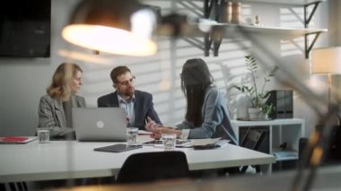 Meslektaşlar ve müşteriler dizüstü bilgisayar ve tabletle strateji konuşuyorlar. Yaratıcı Ofis Üretici İş Arkadaşları Şirket Toplantısı Masasında Bekliyor. Takım Çalışması ve Sosyal Konseptler