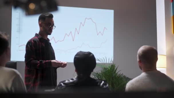 Geschäftstreffen. Office Team analysiert das Wirtschaftswachstum. Junger Mann interessiert sich für Publikum Auf dem Bildschirm Wachstumsdiagramm-Monitor — Stockvideo