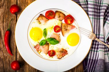 Pastırma ve beyaz bir tabakta sebze ile kızarmış yumurta